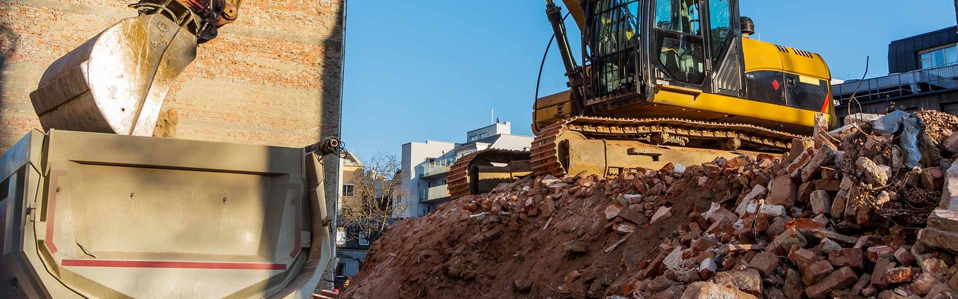 Bagger belädt einen LKW mit Baurestmassen